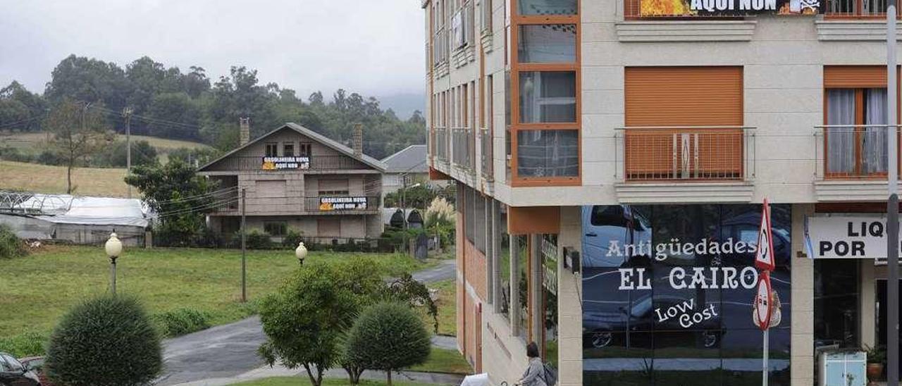 Pancartas de protesta contra la instalación del surtidor en las viviendas que se sitúan al lado del terreno, a la izquierda. // Bernabé/Javier Lalín