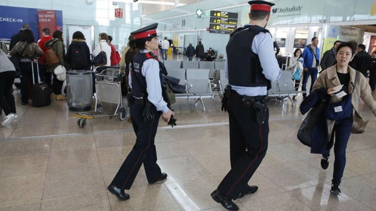 Dos 'mossos' participan en el servicio de vigilancia reforzada del aeropuerto de El Prat.