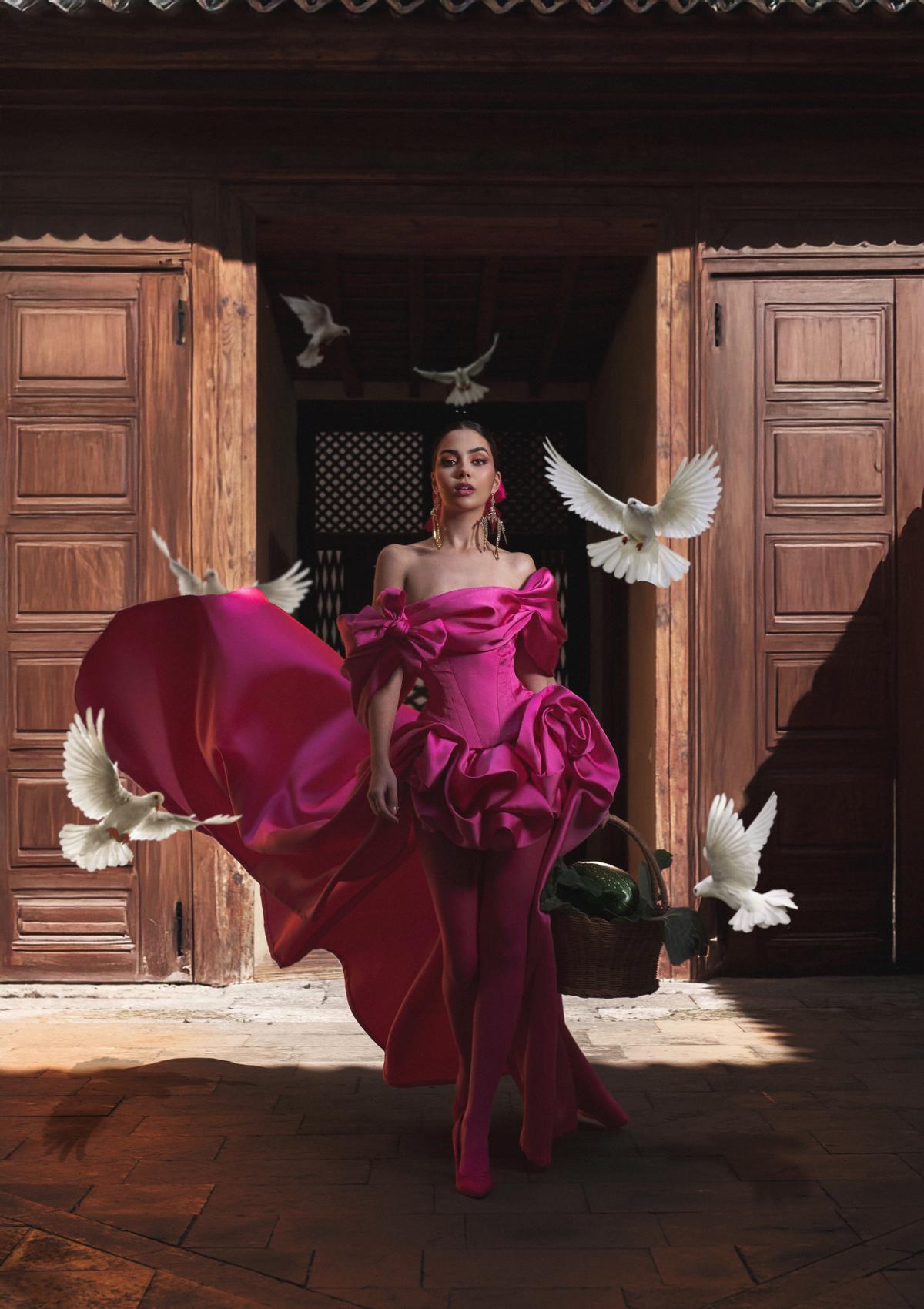 Corina Mrazek, con vestido fucsia con cuerpo ceñido y escote tipo barca y falda corta delante y larga en la zona posterior.