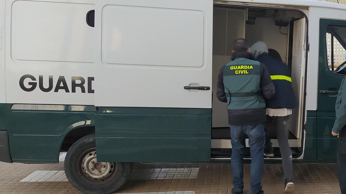 Agentes de la Guardia Civil de Ibiza introducen en el furgón de los detenidos al presunto atracador