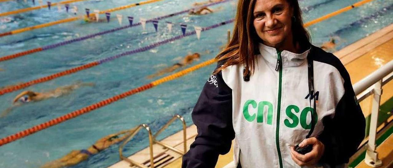 Montse Suárez, cronómetro en mano, en la grada de la piscina olímpica mientras los nadadores entrenan.