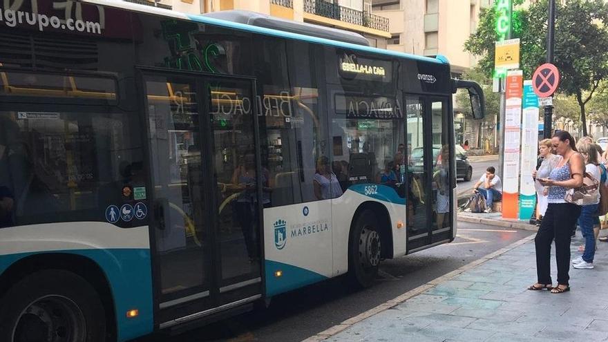 Vecinos esperan el autobús en una de las paradas del centro urbano de Marbella.