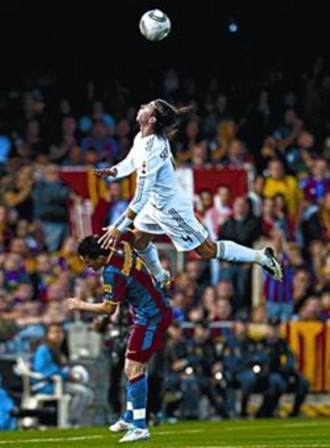 Sergio Ramos vola sobre l’esquena de David Villa.