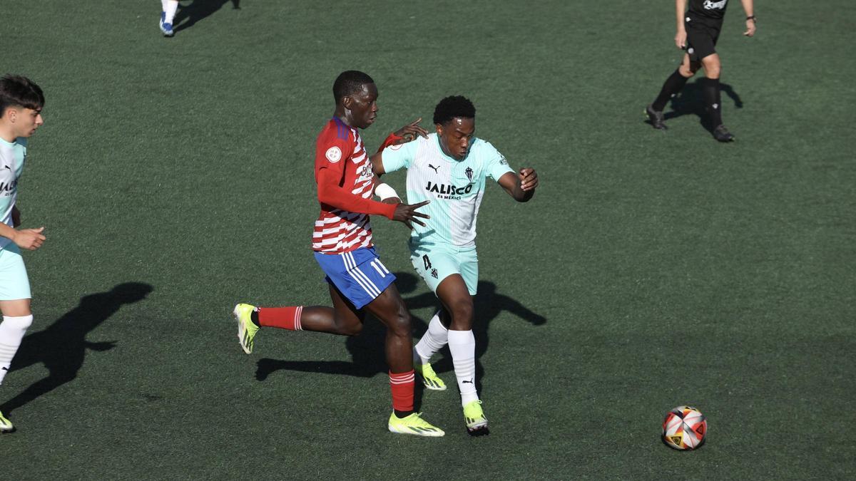 El jugador del Llanera Amadou, a la izquierda, trata de frenar a Mbemba, del Sporting Atlético, en el Pepe Quimarán.
