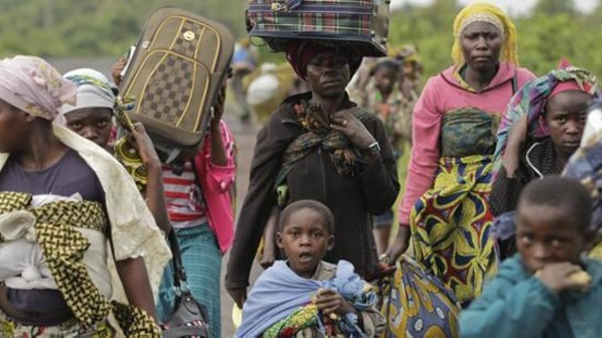 Mujeres y niños de Kimbumba escapan de la violencia de su ciudad en la República Democrática del Congo, a finales de noviembre.