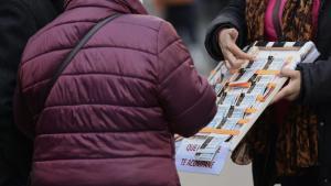 Una mujer compra un décimo de lotería a una vendedora ambulante.