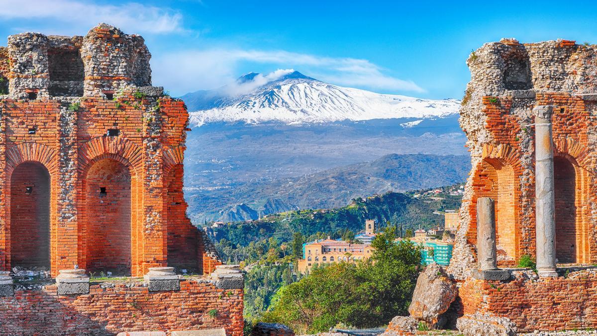 Las ruinas del antiguo teatro griego en Taormina y el volcán Etna de telón de fondo
