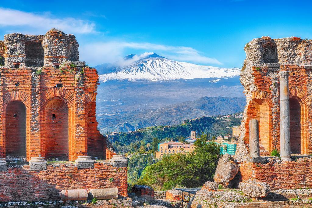 Las ruinas del antiguo teatro griego en Taormina y el volcán Etna de telón de fondo