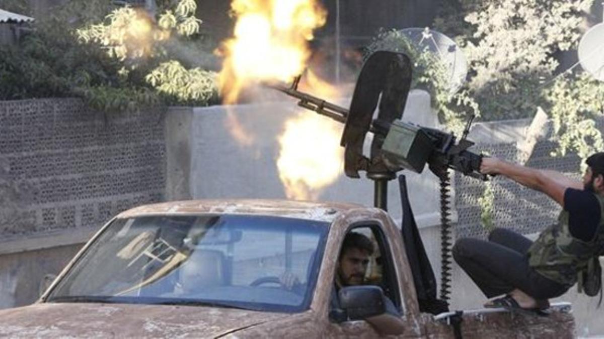Un combatiente rebelde abre fuego contra posiciones gubernamentales en Alepo.