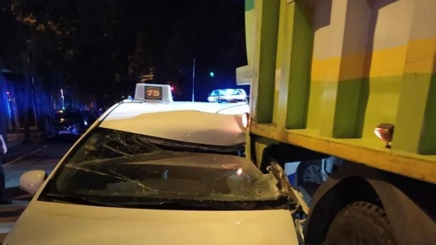 Un taxi queda encajonado bajo un camión de basura en Zaragoza