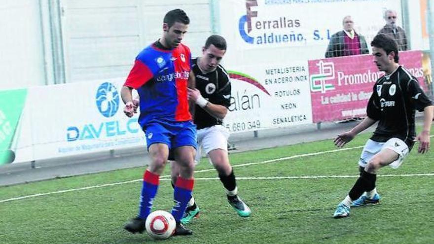 El azulgrana Abraham controla el balón ante la presión de dos jugadores del Lealtad.