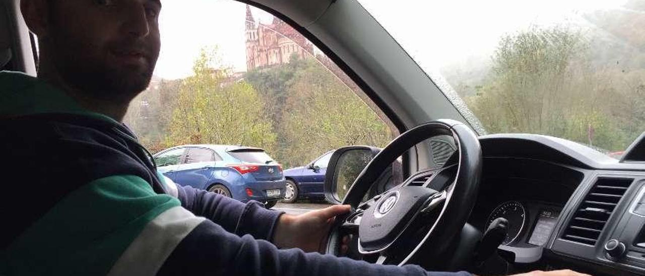 Daniel García, en su vehículo, con la basílica de Covadonga al fondo.