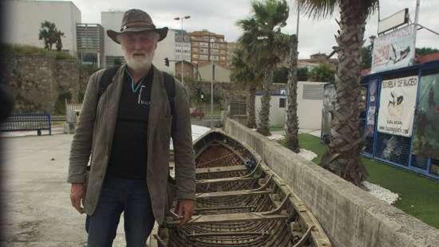 El músico Brendal Begley, uno de los tripulantes que completaron  el Camino de Santiago a remo desde Dublín, junto a la embarcación.