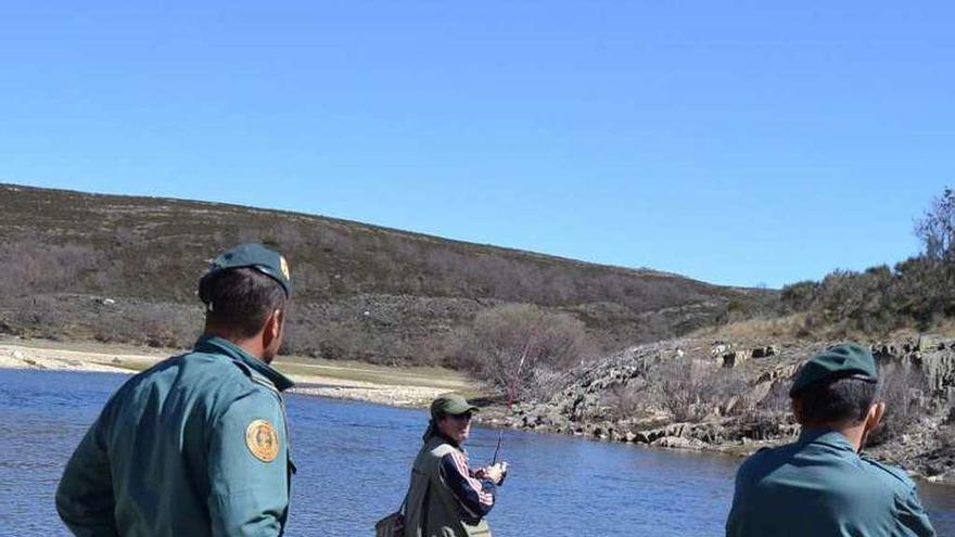 Dos agentes conversan con un pescador en el Tera.