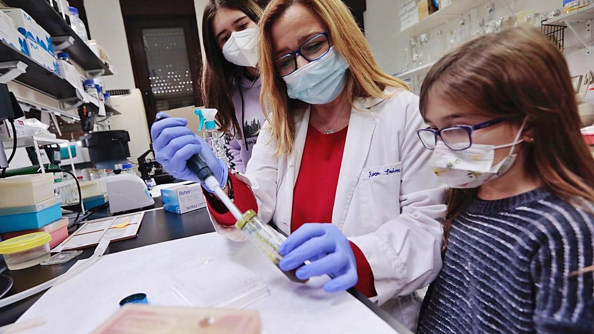 Rosa María Sainz muestra a sus hijas, Raquel (a su derecha) y María Mayo, cómo  se maneja una pipeta en el laboratorio donde investiga sobre el cáncer. Raquel quiere estudiar una carrera de Letras.