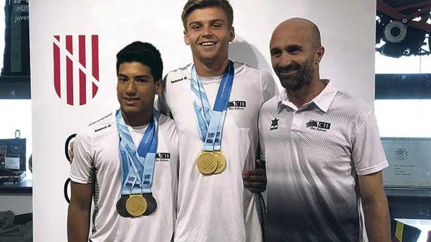 Los campeones Matthew Wade y Adrián Abadía posan con las medallas junto a su técnico Donald Miranda.