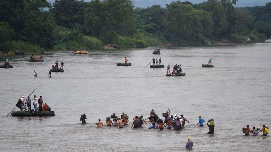Emigrantes hondureños cruzan el río Suchiate para evitar los controles en México. // Efe