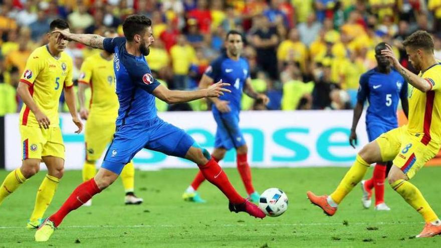 El francés Giroud toca el balón ante la presión de Pintilii.