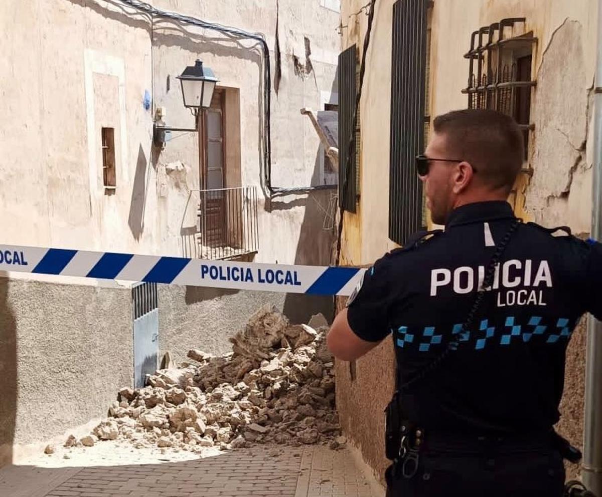Un agente de la Policía Local de Cehegín acordona la zona tras el derrumbe de la casa.