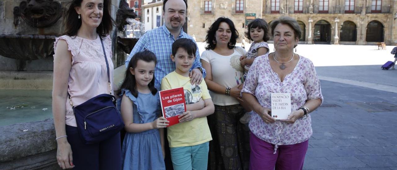 Por la izquierda, Marta González, Claudia Prendes, Luis Carlos Prendes, Alejandro Prendes, Carmen Prendes, con su hija Elisa Rodríguez en brazos, y Carmen Veiga, ayer, junto a la estatua de Pelayo, en la plaza del Marqués, con libros de Francisco Prendes Quirós