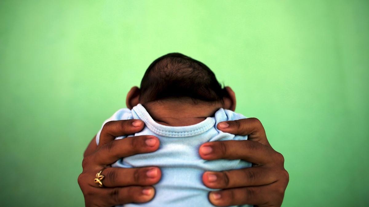 File photo of Jackeline, 26, holding her son Daniel who is 4-months old and born with microcephaly, in front of their house in Olinda