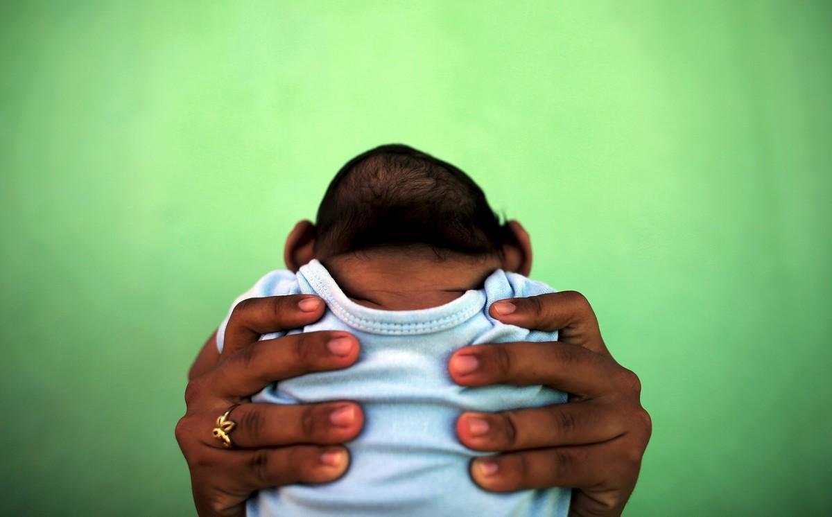 Jackeline, 26, holds her son who is 4-months old and born with microcephaly, in front of their house in Olinda, near Recife, Brazil, in this February 11, 2016 file photo. Evidence is building for the theory that Zika can cause newborn brain defects, and the World Health Organization is promising more answers in weeks, but nailing a definitive link will be neither simple nor swift. Picking apart numerous potential connections between mothers who show evidence of infection with the mosquito-borne virus and babies born with microcephaly, in which the head is abnormally small, will require precision and patience, specialists say. To match Insight HEALTH-ZIKA/MICROCEPHALY  REUTERS/Nacho Doce/Files        TPX IMAGES OF THE DAY