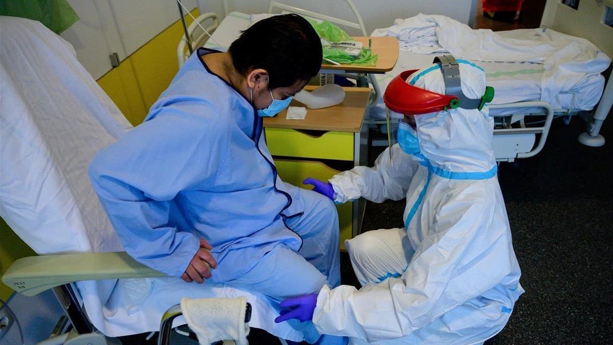 Un fisioterapeuta atiende a un paciente con coronavirus en el Hospital Puerta de Hierro de Madrid, el 13 de mayo del 2020