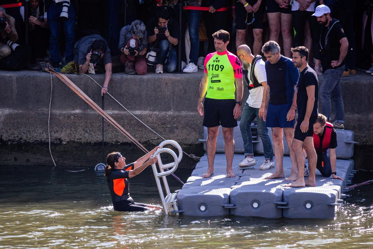 17 July 2024, France, Paris: Paris Mayor Anne Hidalgo (L) enters in the water of the River Seine. Ten days before the start of the Olympic Games, the mayor of Paris has kept her promise and dived into the River Seine, to demonstrate the efforts of the city to improve the quality of the water of Seine. Photo: Telmo Pinto/SOPA Images via ZUMA Press Wire/dpa Telmo Pinto/SOPA Images via ZUMA / DPA 17/07/2024 ONLY FOR USE IN SPAIN / Telmo Pinto/SOPA Images via ZUMA / DPA;Sports;swimming;Olympics;Paris Mayor Anne Hidalgo swims in the Seine River;