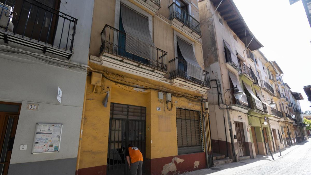 Un hombre observa el interior de la vivienda de la calle Corretgería de Xàtiva desde fuera.