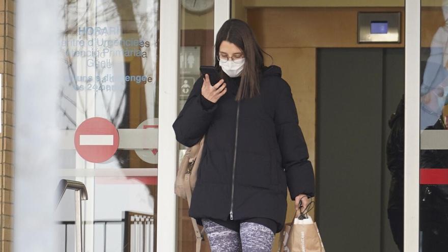 Una dona surt amb mascareta d'un centre sanitàri