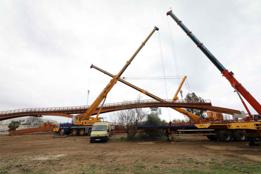 La instalación del último tramo del puente de madera sobre el río Guadalhorce ha comenzado este martes.