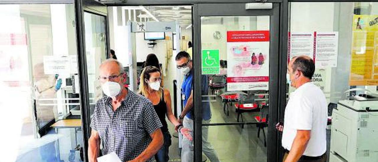 Varios ciudadanos en la puerta de acceso de un edificio administrativo del Prop.