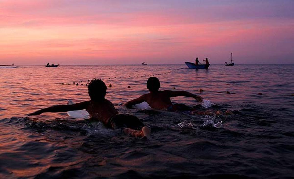 Dos surfistes agafen onades a la platja Punta Veleros a la ciutat de Piura (Perú). Les platges del nord del país, a prop de la frontera amb Equador, estan sent promogudes pel govern per fomentar el turisme a la zona.