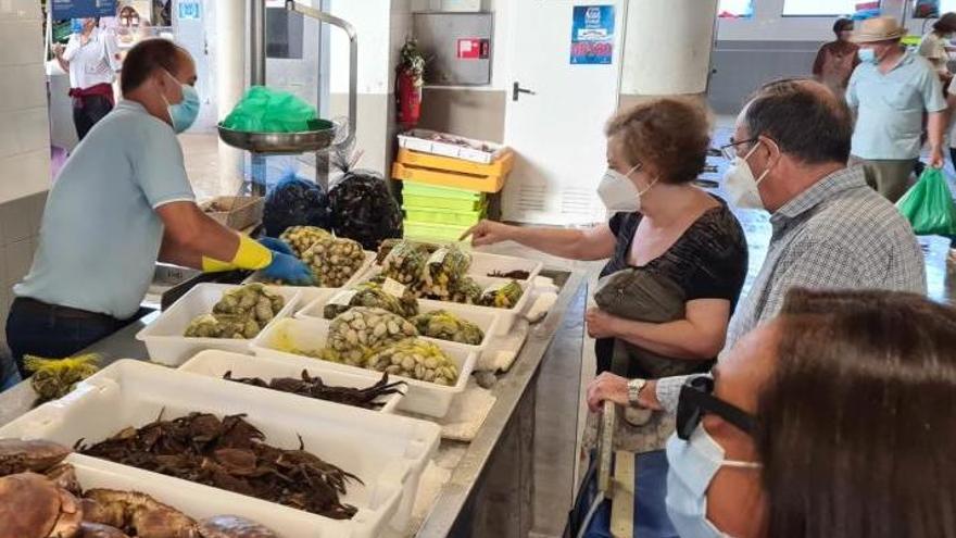 Clientes y pescaderos con mascarilla en el mercado de Vilagarcía. // FdV