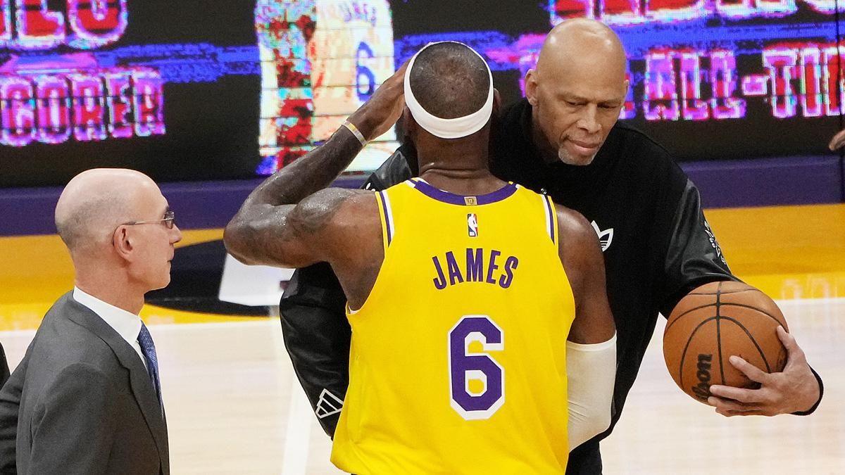 El alero de los Lakers de Los Ángeles, LeBron James, abraza al ex jugador de la NBA Kareem Abdul-Jabbar