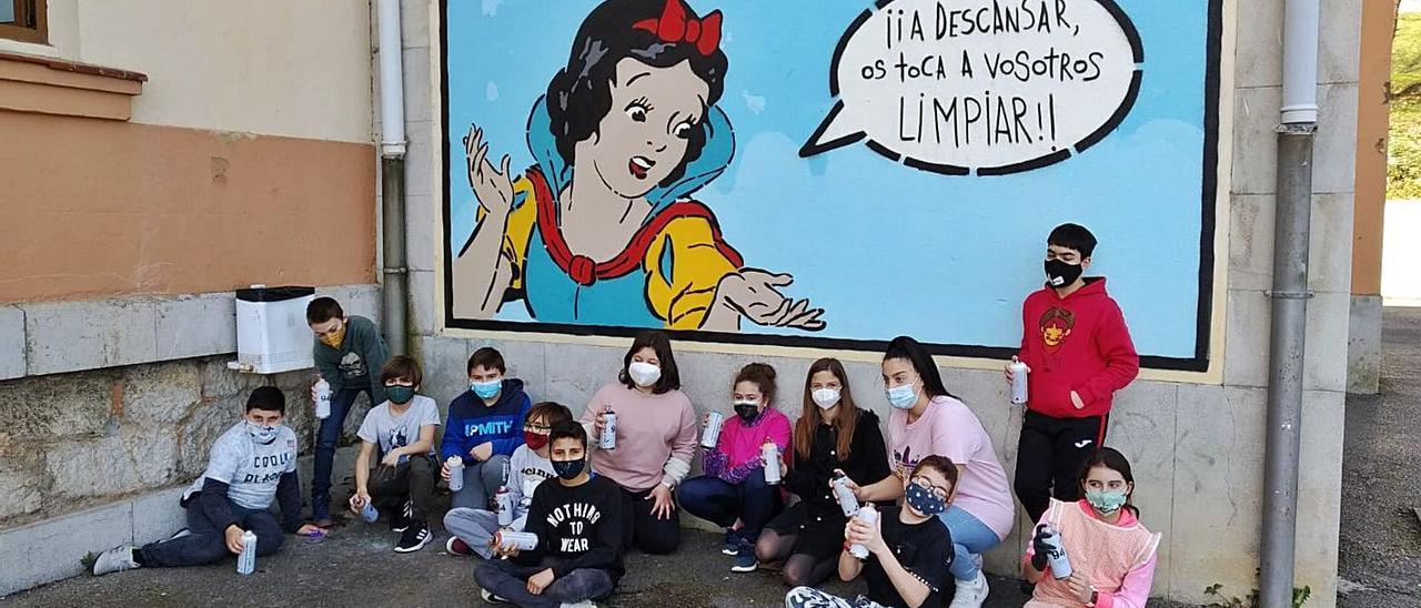 Parte del alumnado de sexto curso de Primaria del colegio público Bernardo Gurdiel, ante uno de los dos grafitis que realizaron en el patio. | Reproducción de S. Arias