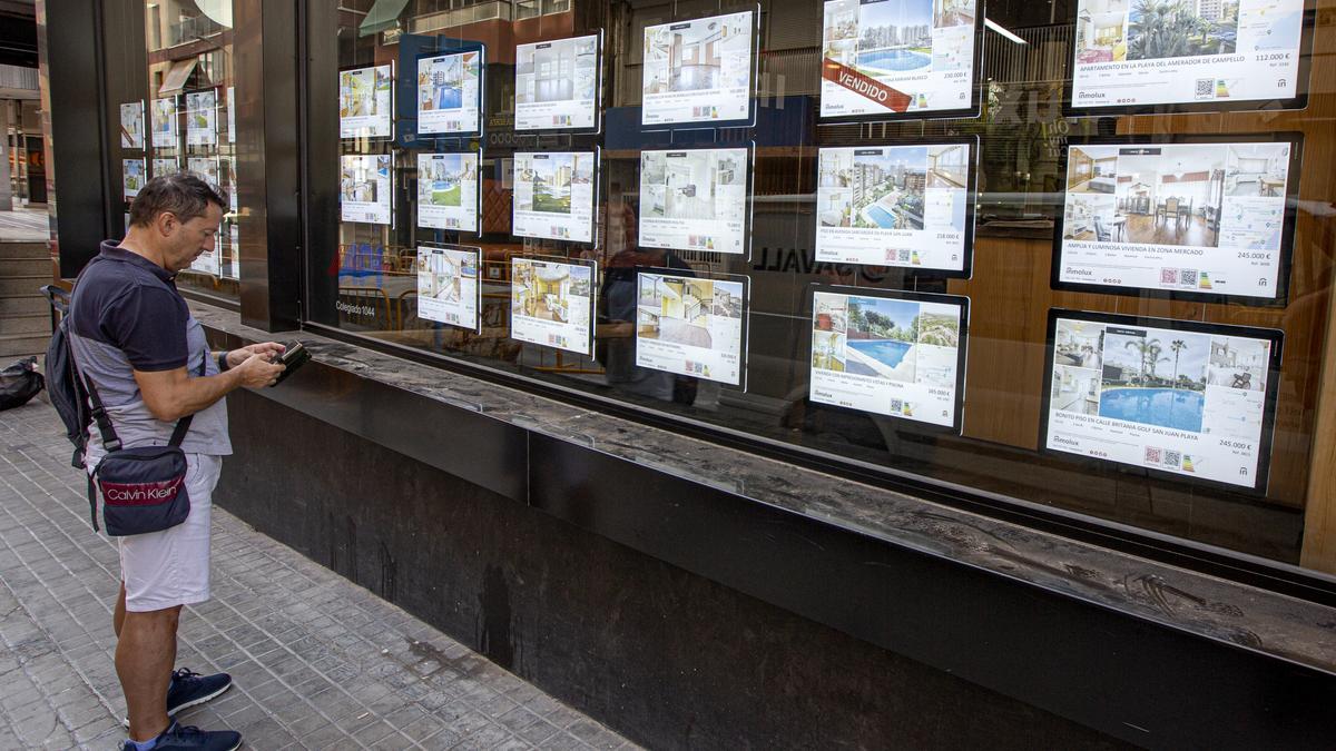 Un hombre observa la oferta de pisos en venta en una inmobiliaria valenciana, en una imagen de archivo.