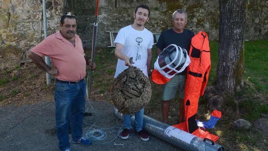 Los voluntarios con el edil Alberto Oubiña con uno de los nidos de velutina y el material usado. // R. V.