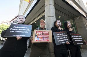 El presidente de la Red de Prevención del Sectarismo y del Abuso de Debilidad (RedUNE), Juantxo Domínguez, acompañado de padres y madres de las víctimas con una máscara del rostro de uno de los líderes de la ’secta’, durante una concentración de afectados por la ’criptosecta’ IM Academy