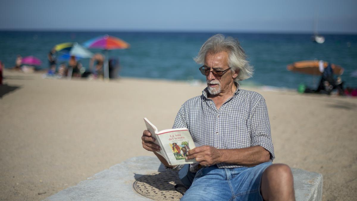 Carlos, un asiduo a la playa badalonesa, releyendo uno de los clásicos de la literatura de aventuras