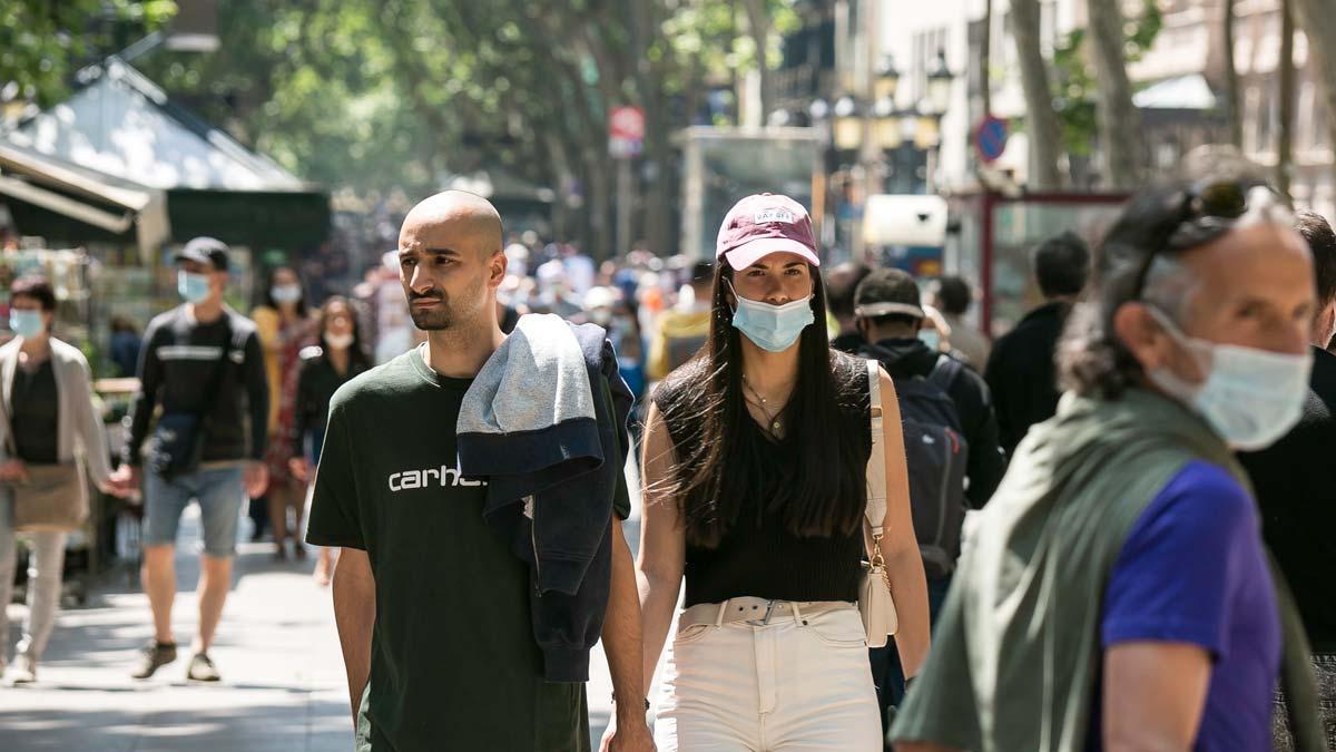 Gente con y sin mascarilla, por la Rambla de Barcelona
