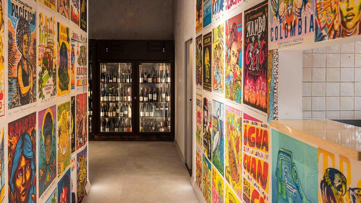 El pasillo que las dos alas del restaurante Chambacú está adornado con carteles coloridos que celebran la cultura latinoamericana.