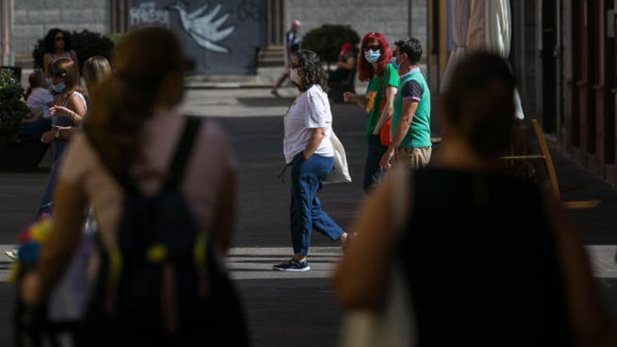 Ciudadanos con mascarilla pasean por La Laguna.