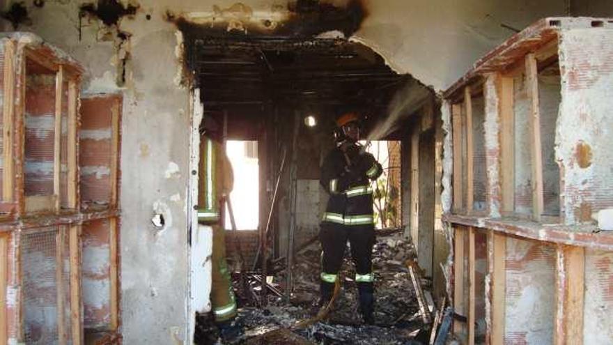 Un bombero trabaja en el piso incendiado.