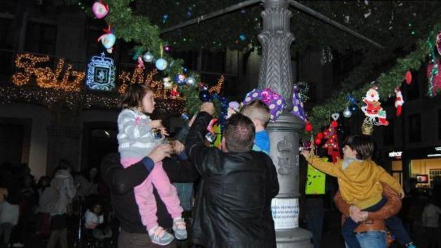 Padres e hijos, decorando el árbol ayer.