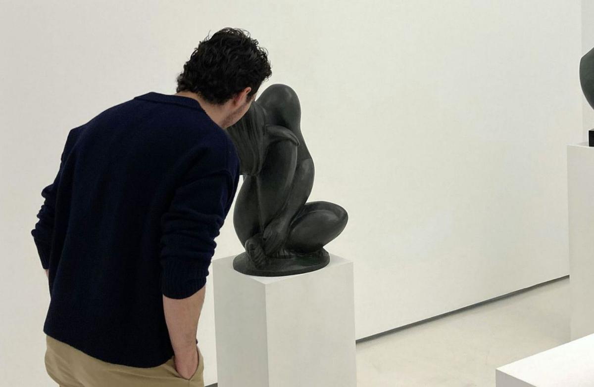 Un hombre analiza uno de los bronces exhibidos. | Cedida