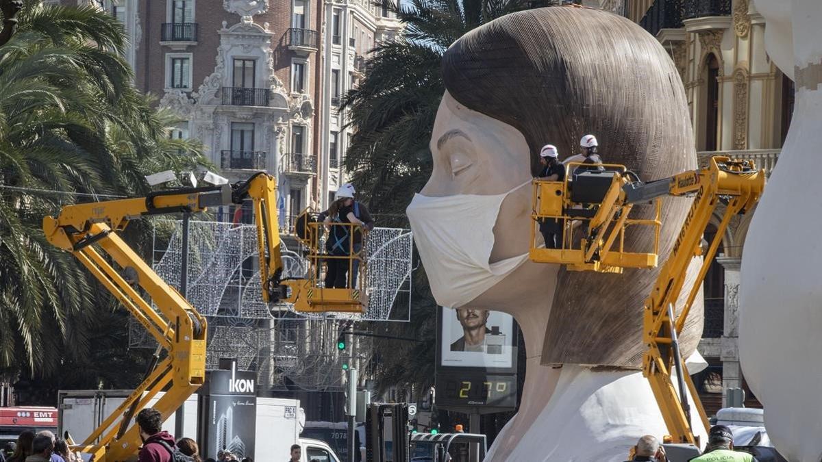 Vista de la falla municipal, a la que le han puesto una mascarilla tras la suspension de la fiesta por la crisis del coronavirus, el 11 de marzo del 2020