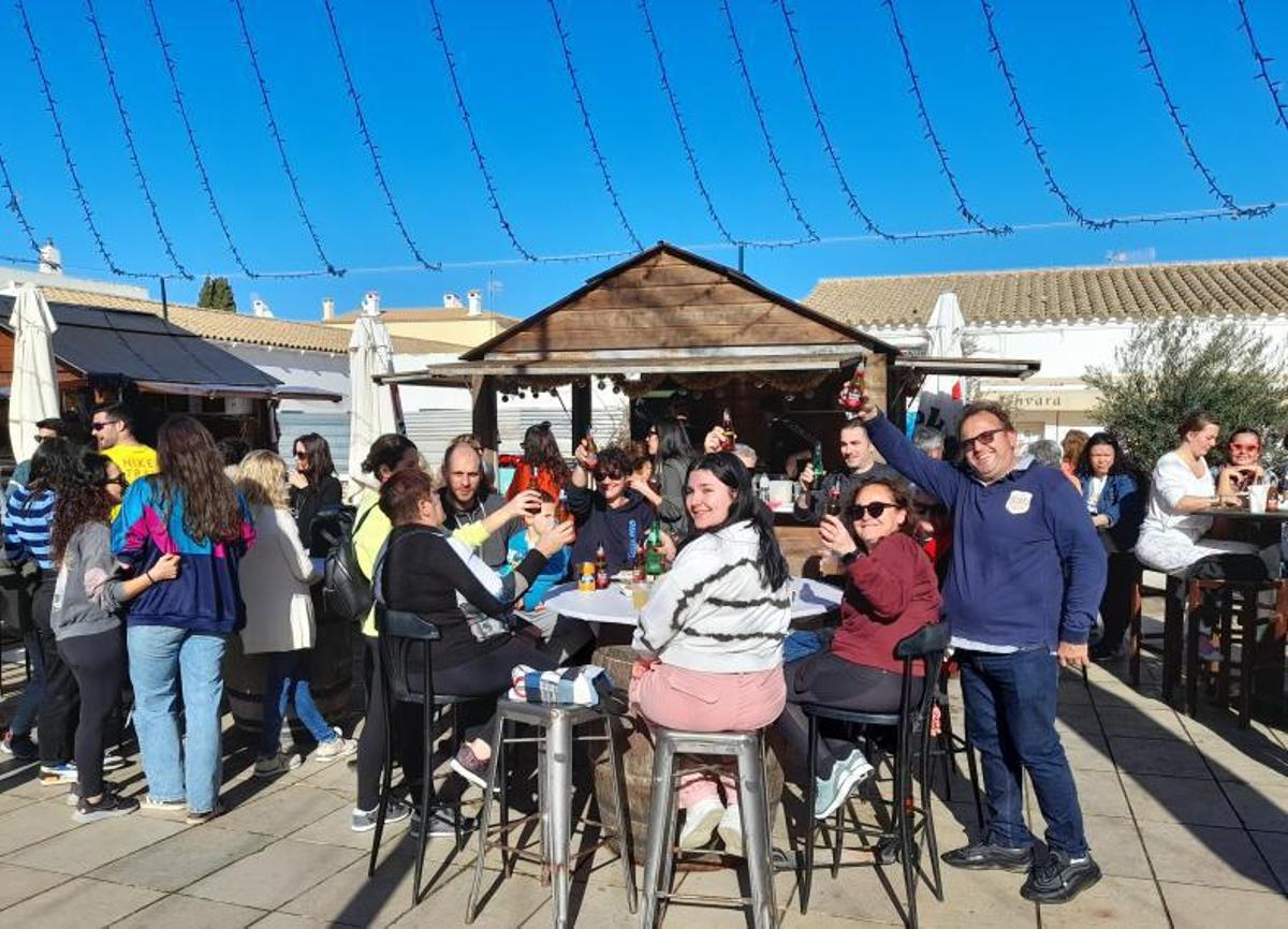 Un grupo de vecinos, en una de las casetas del Mercat de Nadal, brinda por el nuevo año 2023. | C.C.