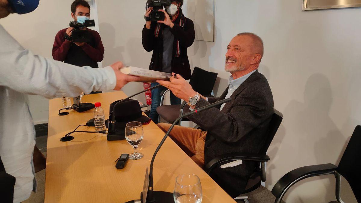 Pérez-Reverte entrega una ejemplar firmado de 'El italiano' a uno de los asistentes.