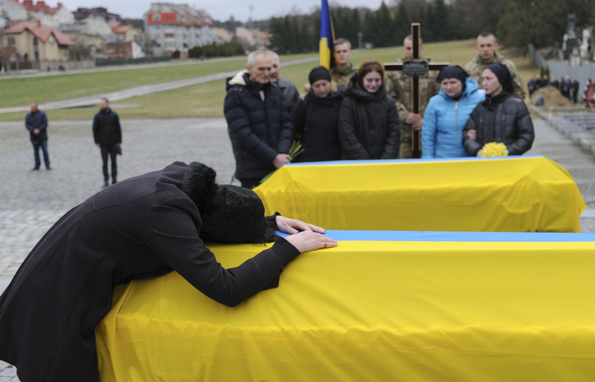 Una mujer se lamenta encima de un fénetro durante un funeral de militares ucranianos asesinados en Lviv.